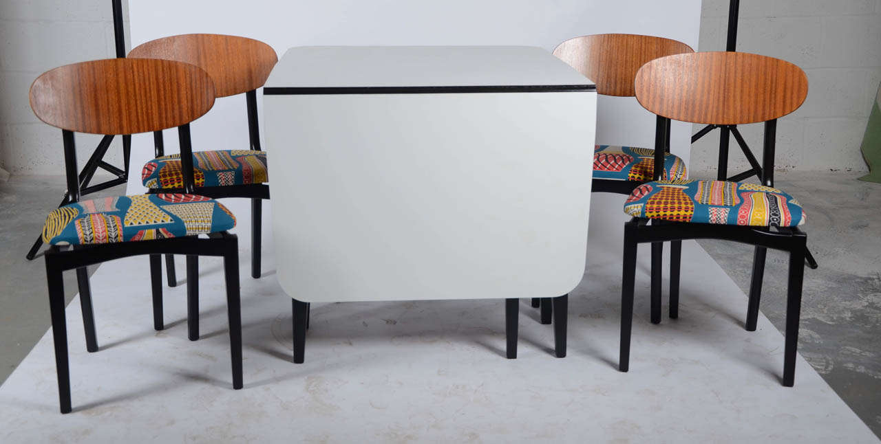 A 1960's G-Plan ebonised table and 4 chairs. The table has a white veneer top and the chairs have been newly upholstered in a fabric design from the world renowned Sanderson & Co, to replicate a near original look. Gate leg table Dimensions: 75