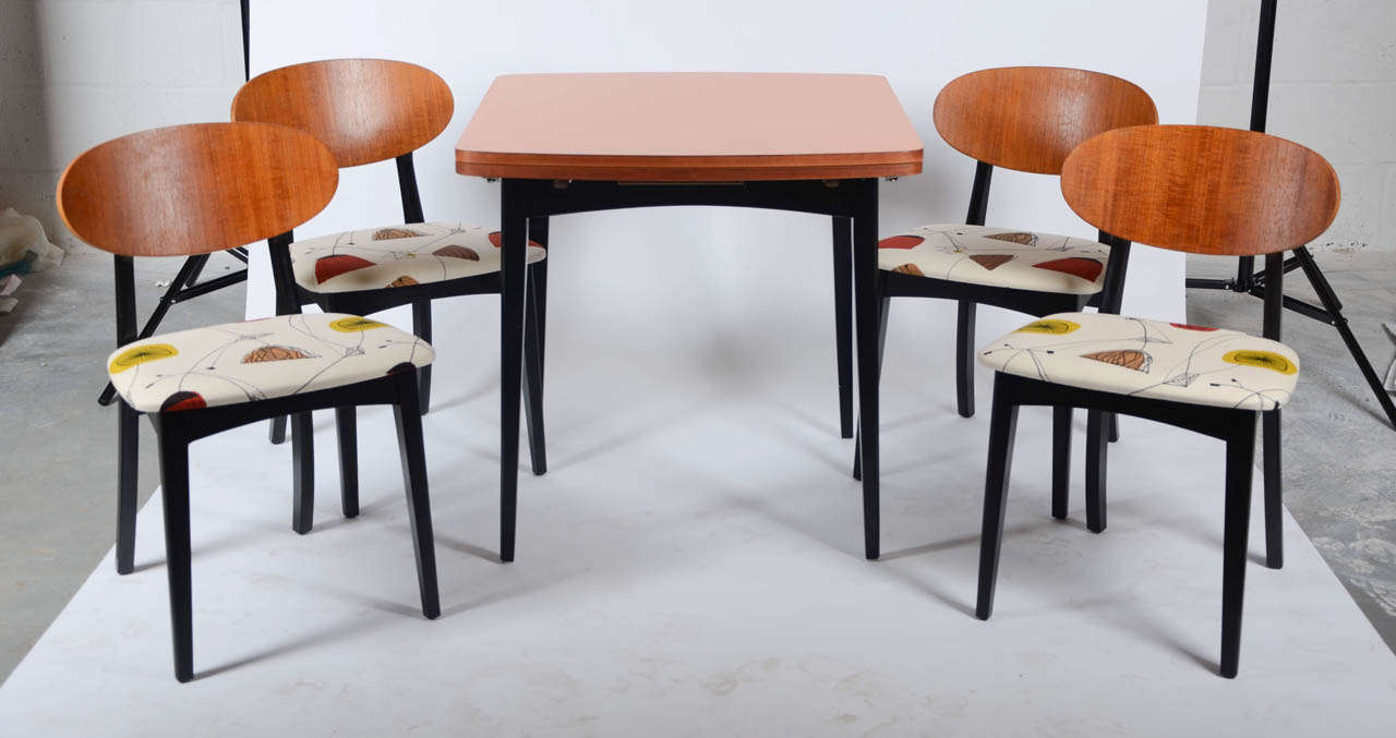 A 1960's G-Plan dining table and four matching chairs newly upholstered in a fabric design from the world renowned Sanderson & Co, to give a near original look.The table top being covered in orange veneer. Dimensions: Table 75 cm(H) x 76 cm(D) x 83