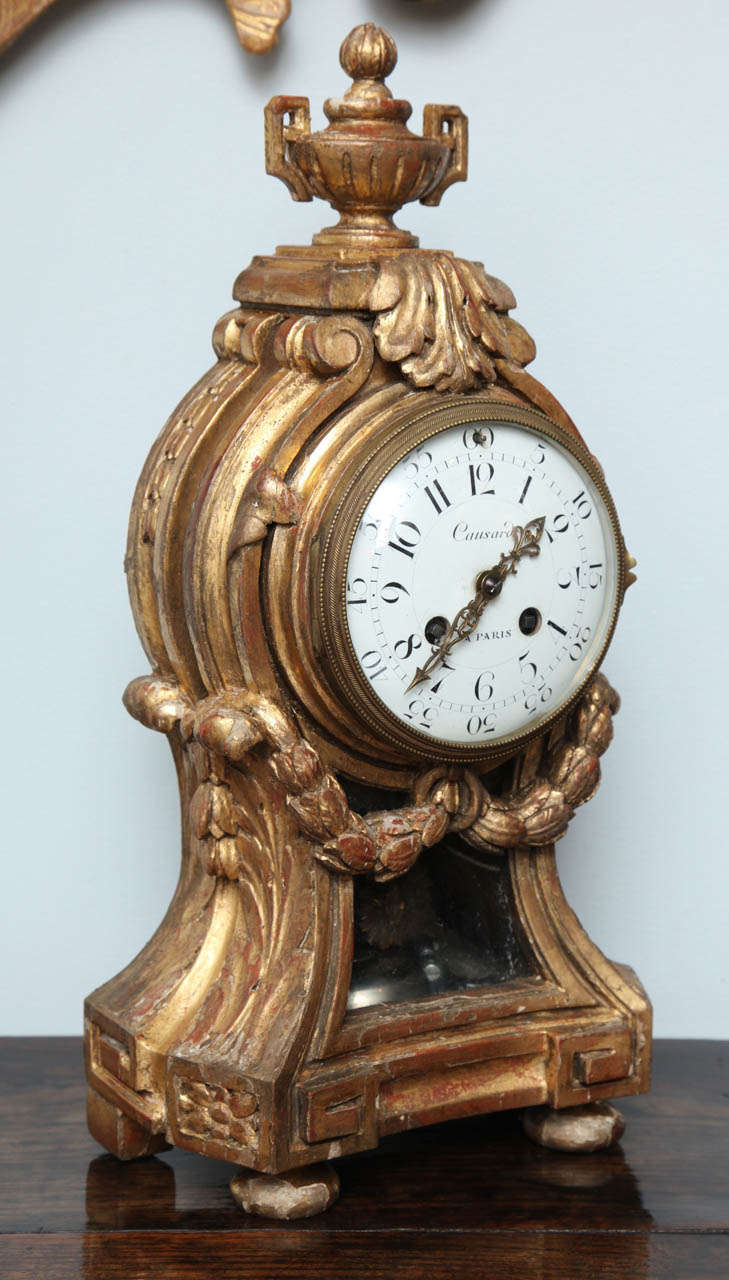 Fine Louis XVI giltwood clock by Causard, Paris, having an urn finial over acanthus carved crest, the balloon body with laurel draped swags, the base with Greek key pediment over turned flattened ball feet, the movement stamped Planchon, Paris.