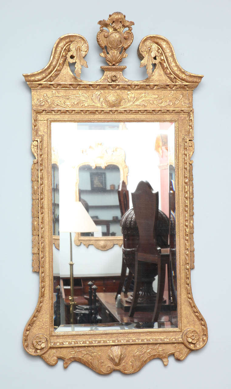 Very fine George II period gilt wood mirror, the swan neck pediment with foliate carved scrolls surrounding central cartouche, the whole with egg and dart molding, the base with shell carving surrounded by scrolls, the background with punched