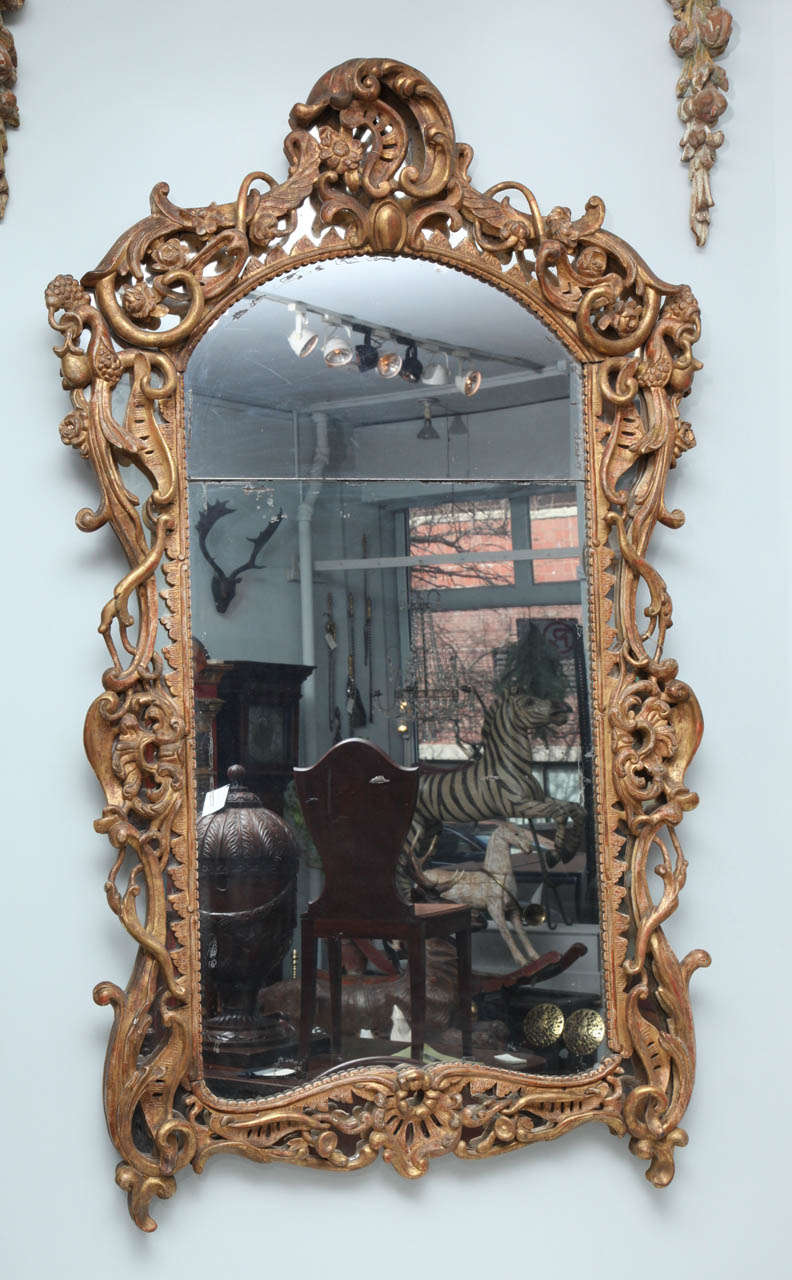 Very fine Louis XV period gilt wood mirror, the frame with foliate, fruit and vine carving over original border glass, the center with two plate which appear original, the gilt surface beautifully patinated and the whole very exuberant and organic