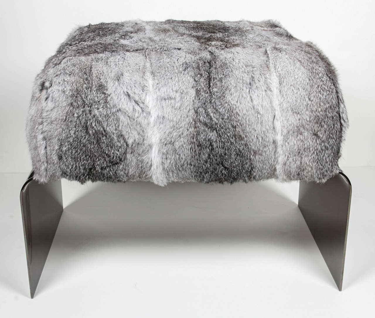 Stunning mid-century modern style stool with streamlined waterfall base design in polished black nickel. The bench is upholstered in luxurious rabbit fur in variant hues of grey. Great accent piece for any room and also great as an ottoman.