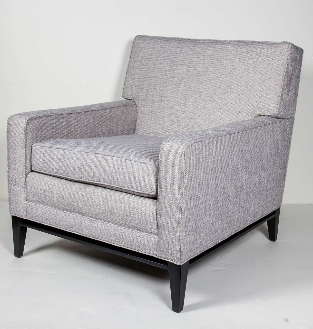 Modernist club chair and matching ottoman set. Mid-Century design with streamline form, consisting of clean lines and elegant profile. Newly upholstered in a grey or white woven basket weave fabric with simple self-welt details. Legs and bases are