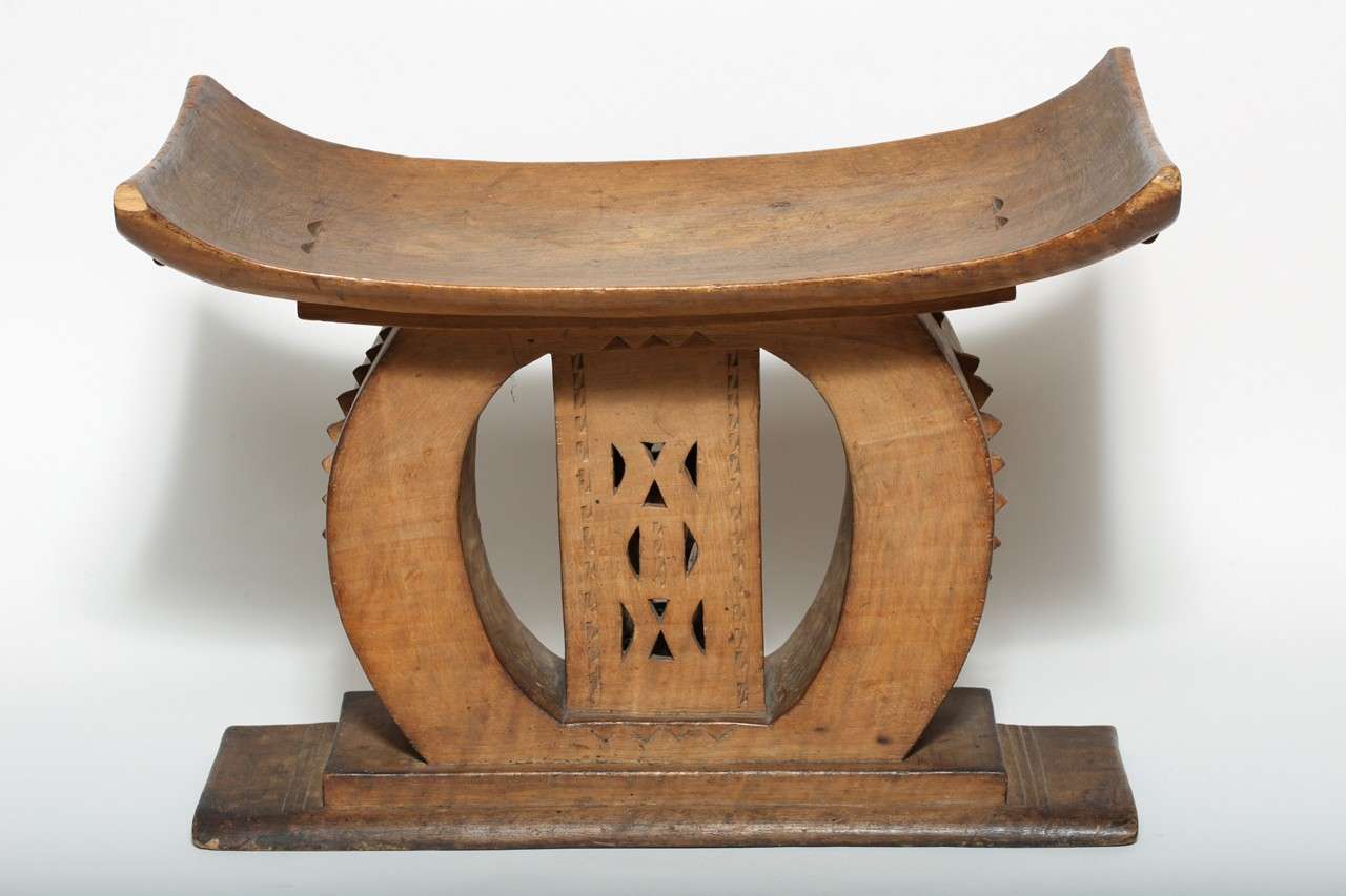 This elaborately carved stool was typically reserved for a member of the royal family.
Tribal stools like this one were an influence on French Art Deco.

There is a 3'' small crack on the far right corner of the seat shown in Image