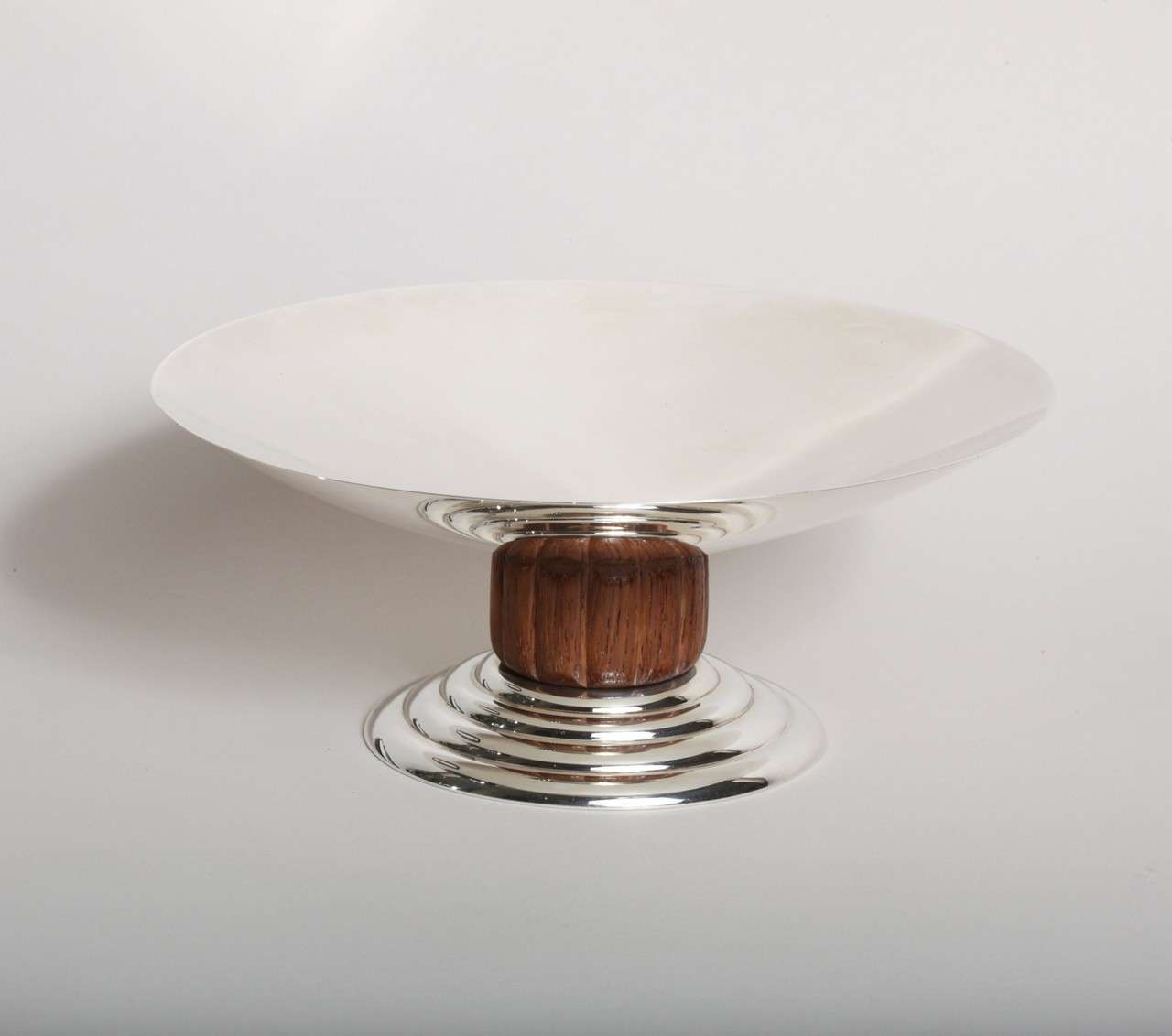 Compotier en argent reposant sur une tige cannelée en bois dur et un pied circulaire à gradins par Jean Puiforcat (1887-1945).
Canif imprimé Jean E. Puiforcat/ EP avec poinçons en argent 950 français