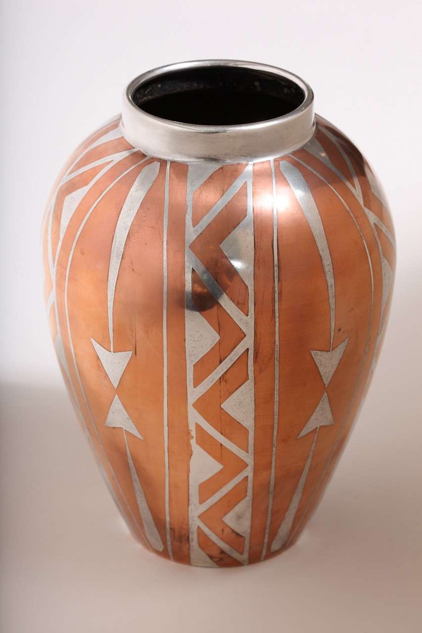 A dinanderie vase with a repeating stylized geometric motif in copper and silver by Luc Lanel for Christofle.
Stamped:  