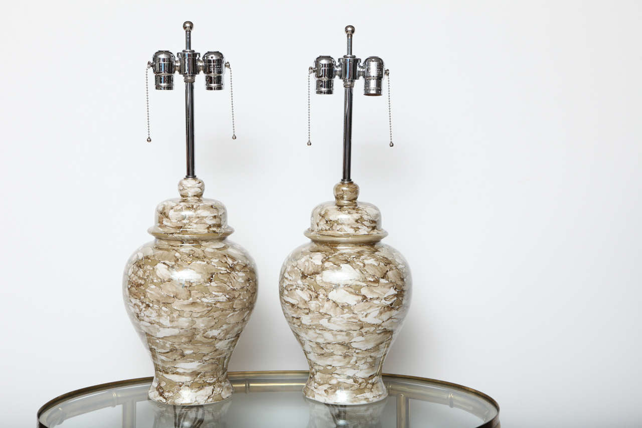Pair of ceramic ginger jar lamps in a mottled neutral pattern.  USA, circa 1960.  Rewired with new hardware in patinated (bronze) hardware.  Each lamp takes two standard US bulbs, 75 watts max each.

Dimensions (in inches):
24.25" overall