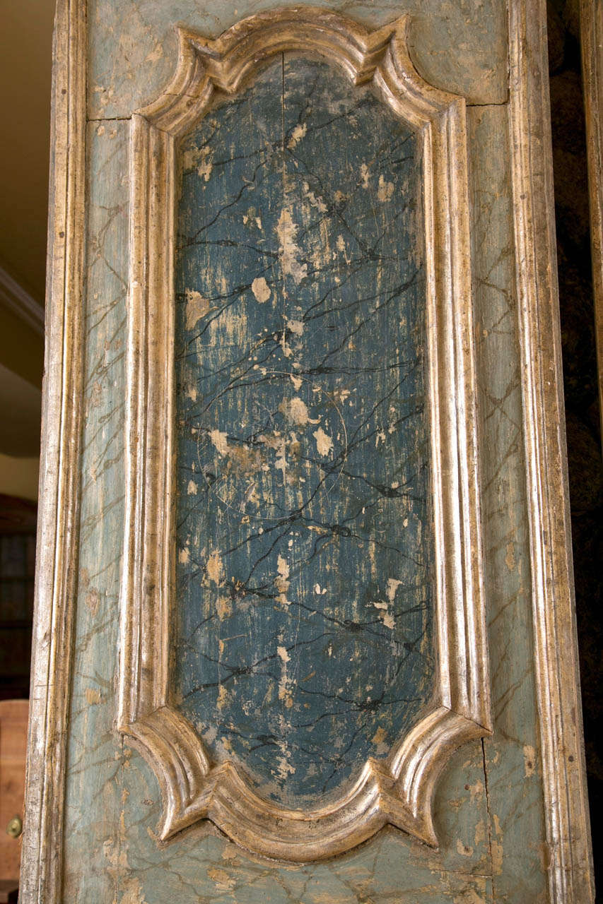 Two Louis XV style faux painted door panels, doors are 19th Century, painted later, painted in shades of blue and green to resemble porphyry marble, with gilded and carved reserves.
