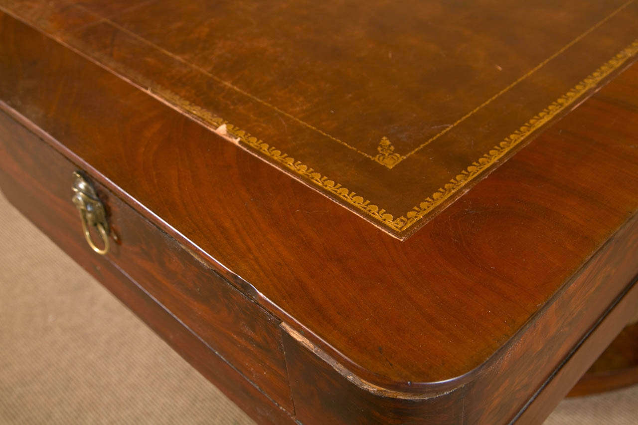 DIrectoire Style Mahogany Gentleman's Desk, circa 1860, one side with a long drawer, the other with faux drawers, the handsome gilt embossed leather top and gilt bronze appliqué details, all on turned base and stretcher.