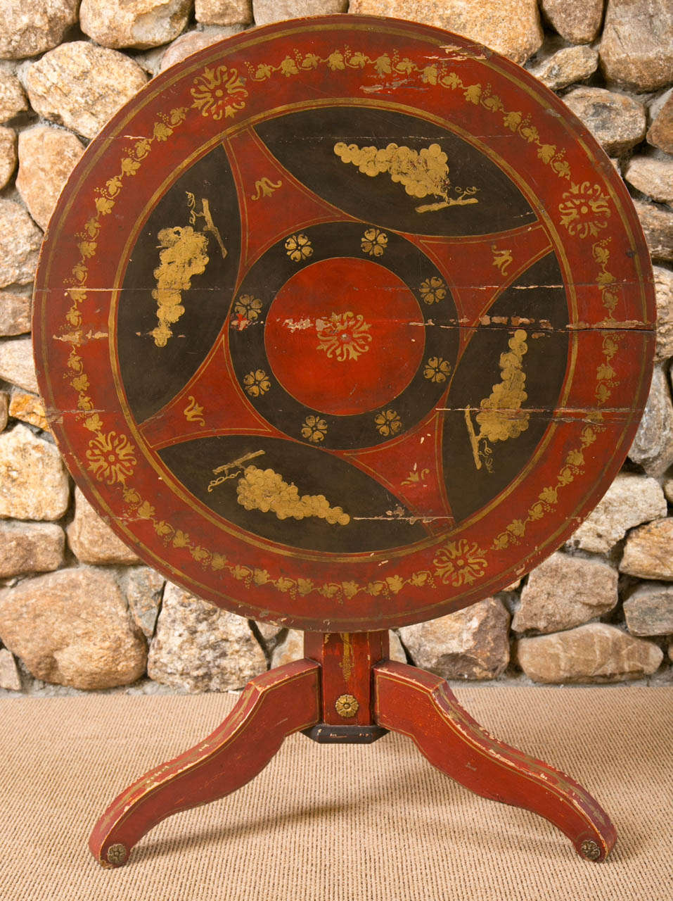 Continental Painted Wood tilt top Circular Center Hall Table, mid 19th century,  the wonderful design in colors of red and yellow on a dark ground, on a tripod base