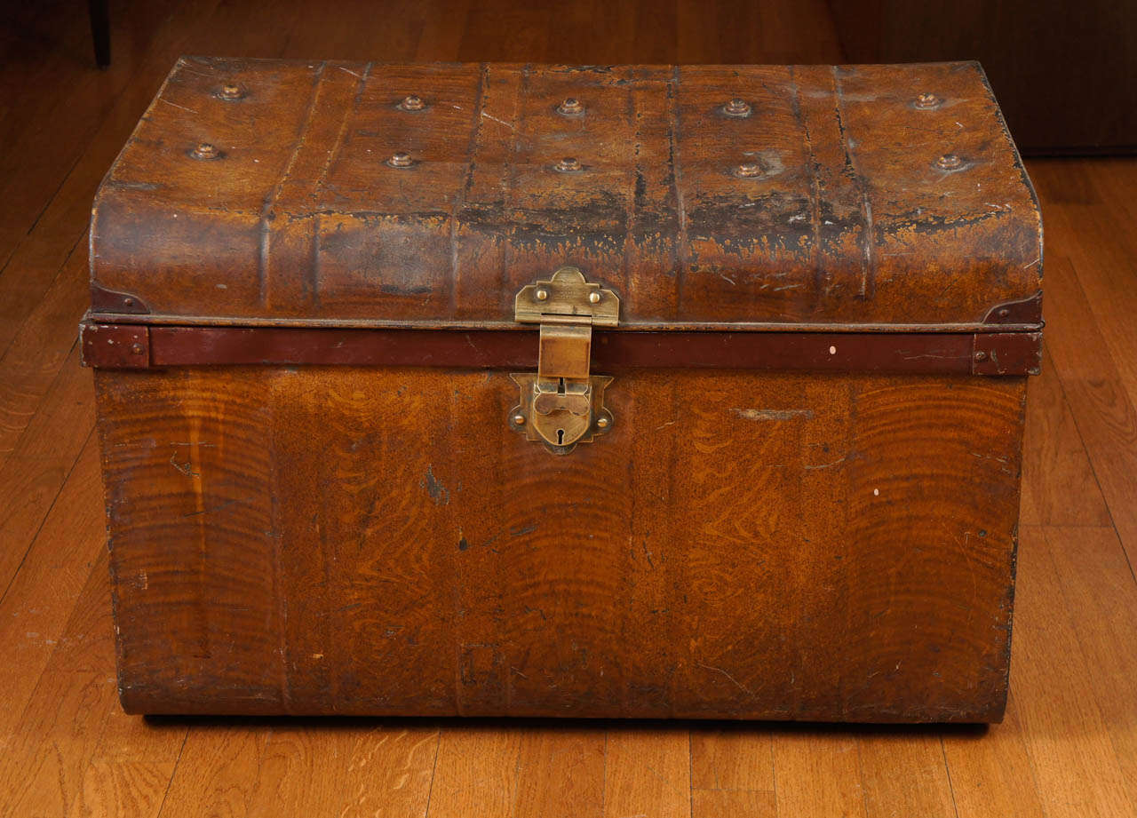 a wonderful vintage trunk! It's distressed, used exterior, only adds to its charm.
the interior is blue. the heavy knobs on top, protected the trunk, when other trunks were stacked on top. 
a handsome, solid brass lock is signed, 