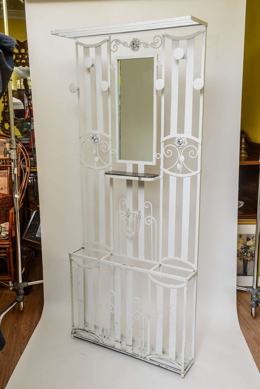 Art Deco French iron entry hall stand or tree with original marble inset shelf as well as original drip pan and appointed with a mirror. Outfitted for umbrellas. Painted white. It is fashioned with a top shelf for small luggage or hats. Six hooks.