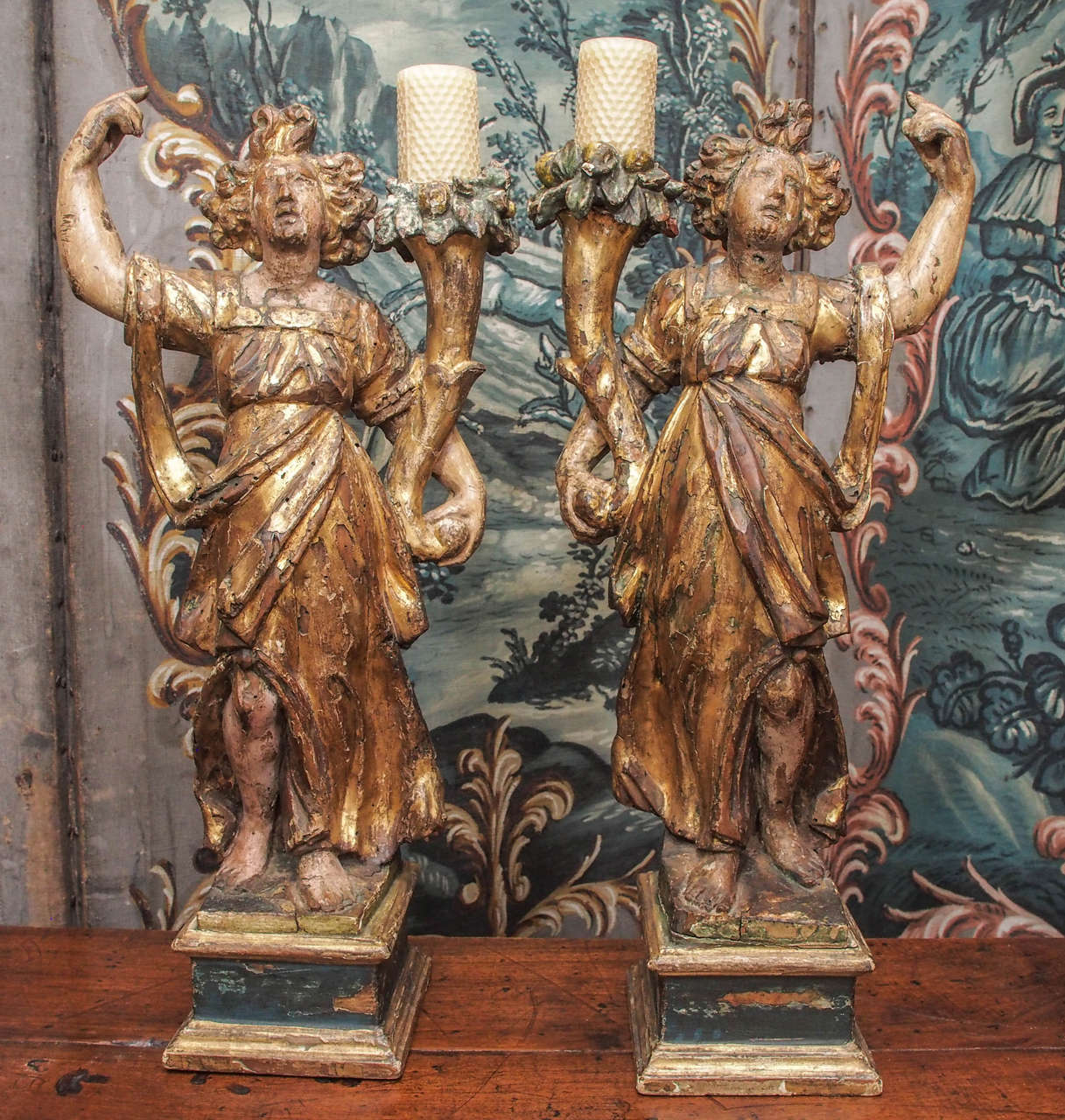 Pair of Italian giltwood maidens in classical dress with cornucopia now holding candles.