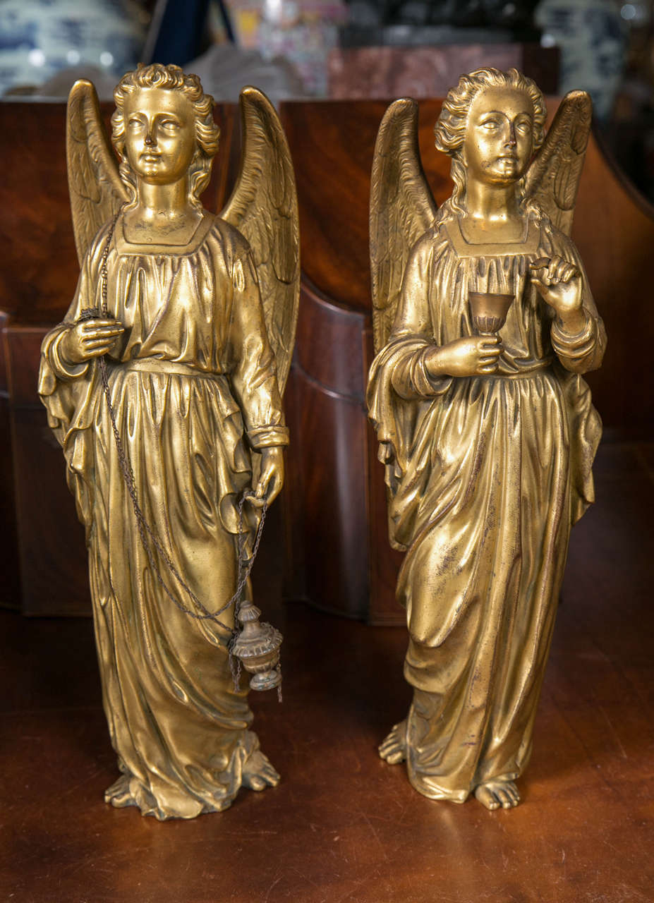 Each female angel with large chased wings. Each wears draping robes. One carries as a wine cup, while the other a chain and what appears to be an insensor. Beautiful faces and fine modeling. Small casting flaws. Mercury gilding in excellent worn