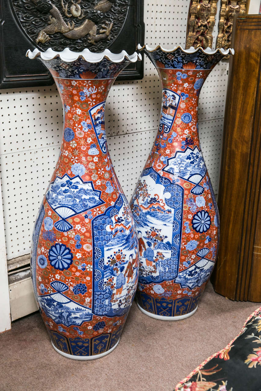 This pair of porcelain vases are in traditional Imari colors and design. The neck flares to a rippled edge. They are in perfect condition.