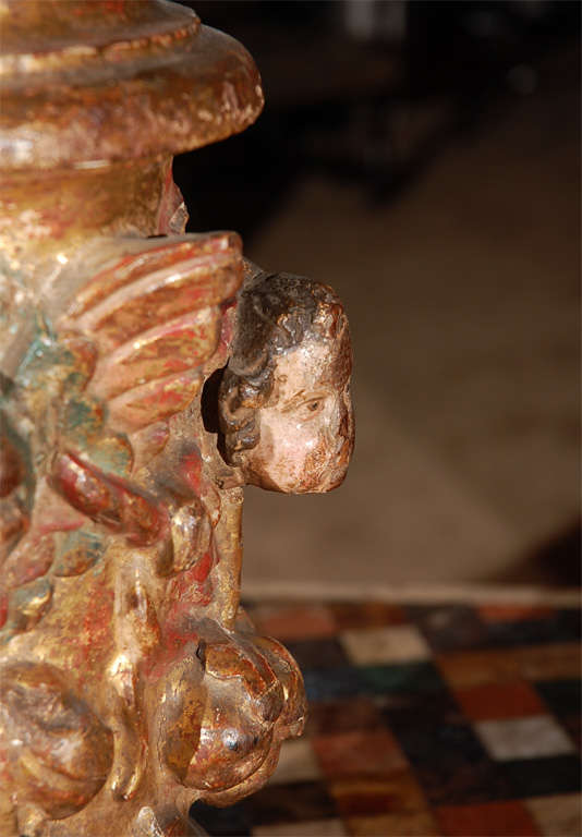 Colonne italienne en bois sculpté et doré avec des visages d'angelots et des volutes.