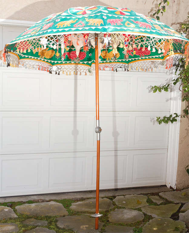 This is such a great umbrella--it's made of thick Indian cotton, and looks fab open or closed. It is covered with stitched animals and patterns, and when it's open, the inside is a carnival with fringe, hanging mirrored stars, another hanging piece