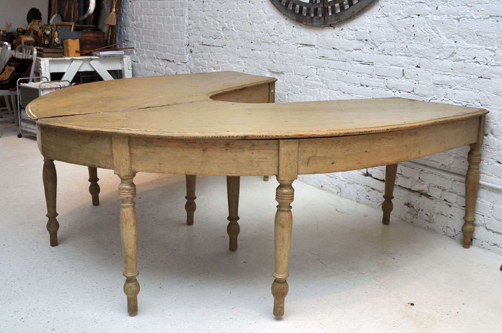 A pair of curved tables that can be used together as a table with a horseshoe shape. Once an Industrial table used in some sort of workroom. Tables are numbered with metal disks of 302 and 304.