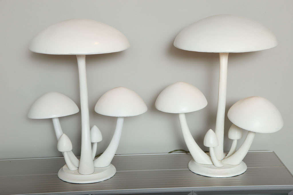 Originally garden lights from a New Hampshire amusement park, these sculptural mushroom lamps are perfectly scaled as table lamps with a whimsical twist. The tall center mushroom conceals a four light socket cluster. Great old white paint has a