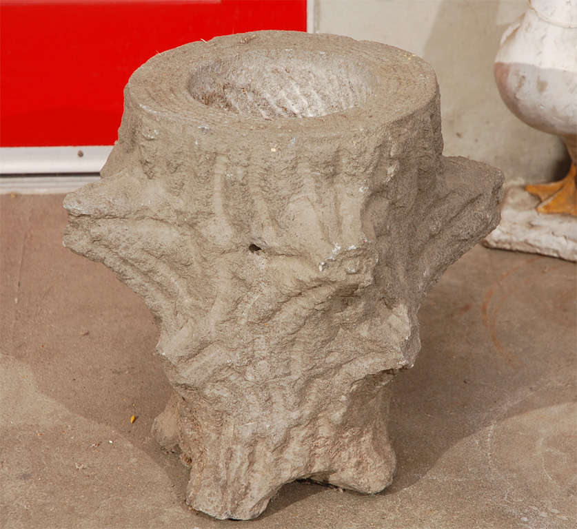 An interesting faux bois hard stone planter in the shape of a tree trunk, having simulated bark and tree ring effects along with knots and a band inscribed 