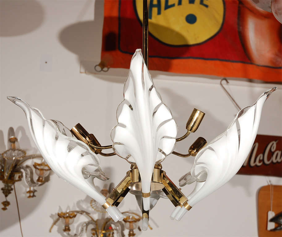 This delightful Murano chandelier, circa 1960, has six variegated petals as shades. The white and clear forms make an appealing contrast to the brass body of the chandelier. 