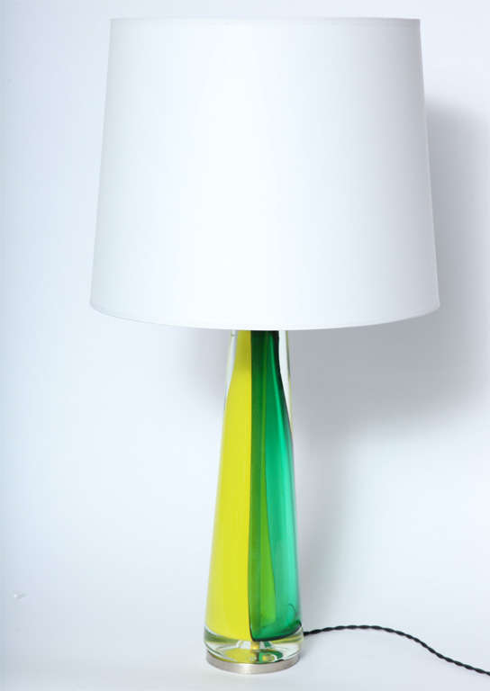 A pair of sculptural form table lamps in Italian art glass by Seguso, produced circa 1960s, each crafted of vibrant lime green and yellow Murano glass, accented by black bands with silvered brass bases and mounts.
Shades not included