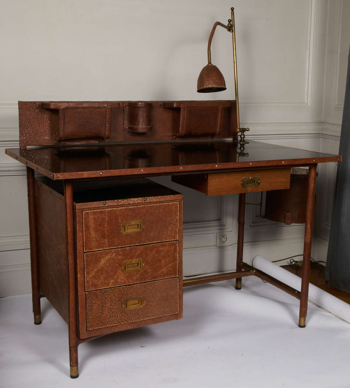Rare Jacques Adnet desk with lamp, book rack and bin.