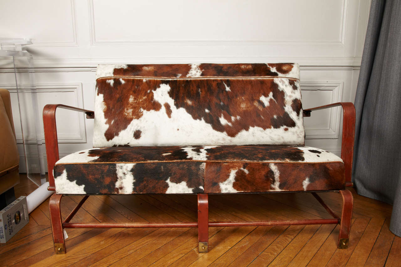 Great two places sofa in stitched leather covered with cow skin,
circa 1950s.
By Jacques Adnet.