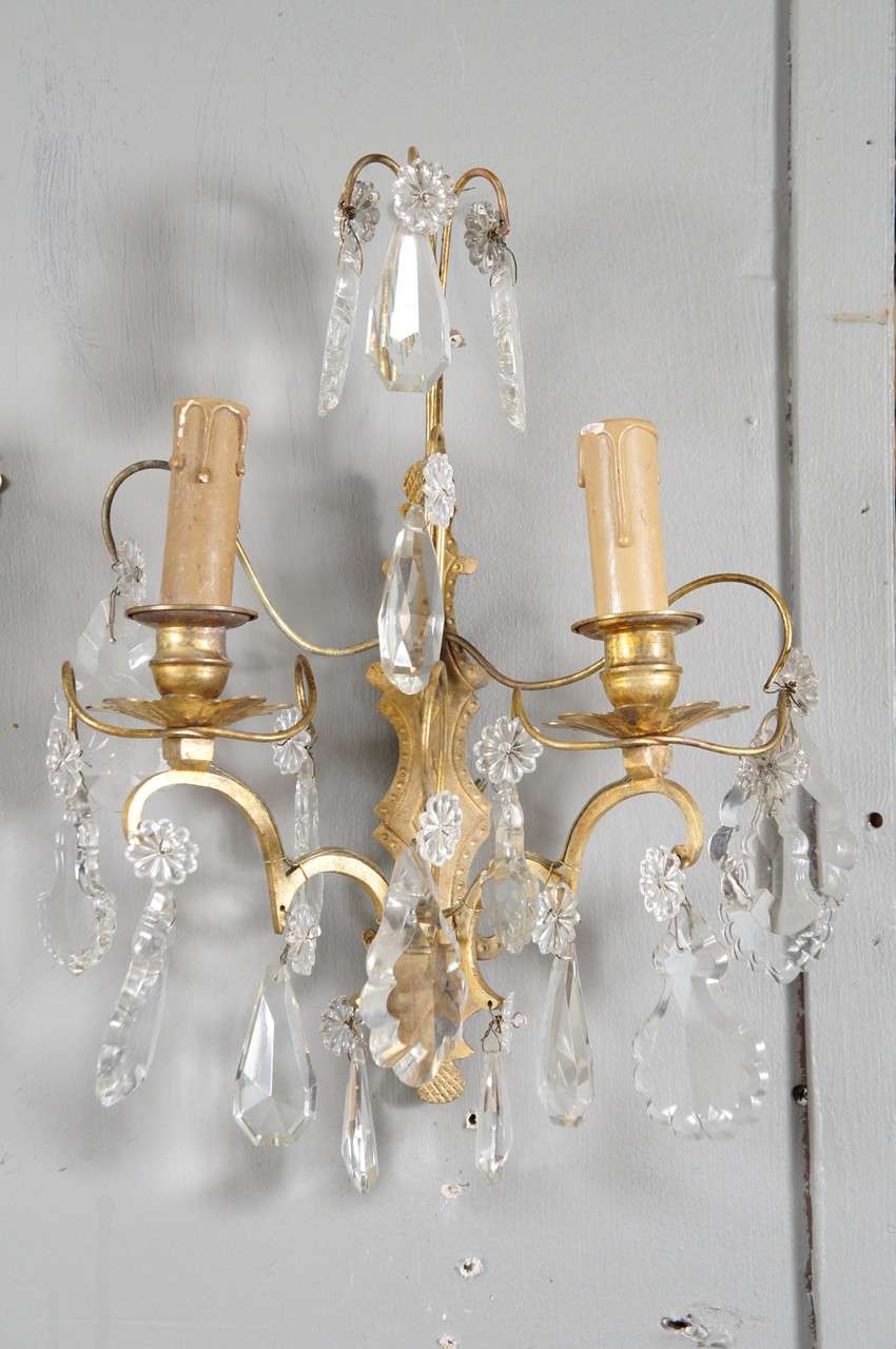 French rococo-style gilt-metal & crystal sconces electrified for small socket light bulbs. Crystal drops and florets.