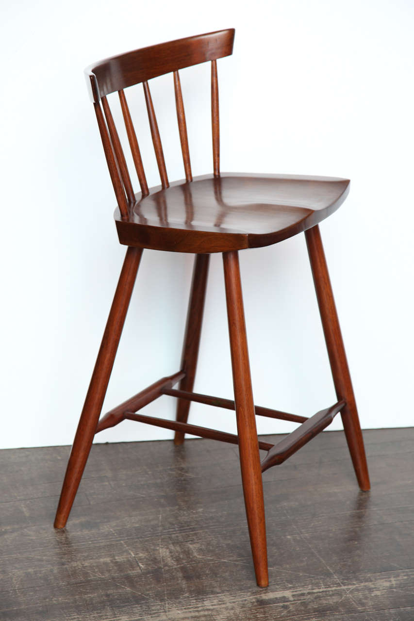 Sculptural, solid walnut chair, handmade in the Nakashima Studio.   Elegant stool-height chair, perfect for use at a bar or counter.   This chair has been sitting in a private collection for many years, and has an illegible name scrawled into the