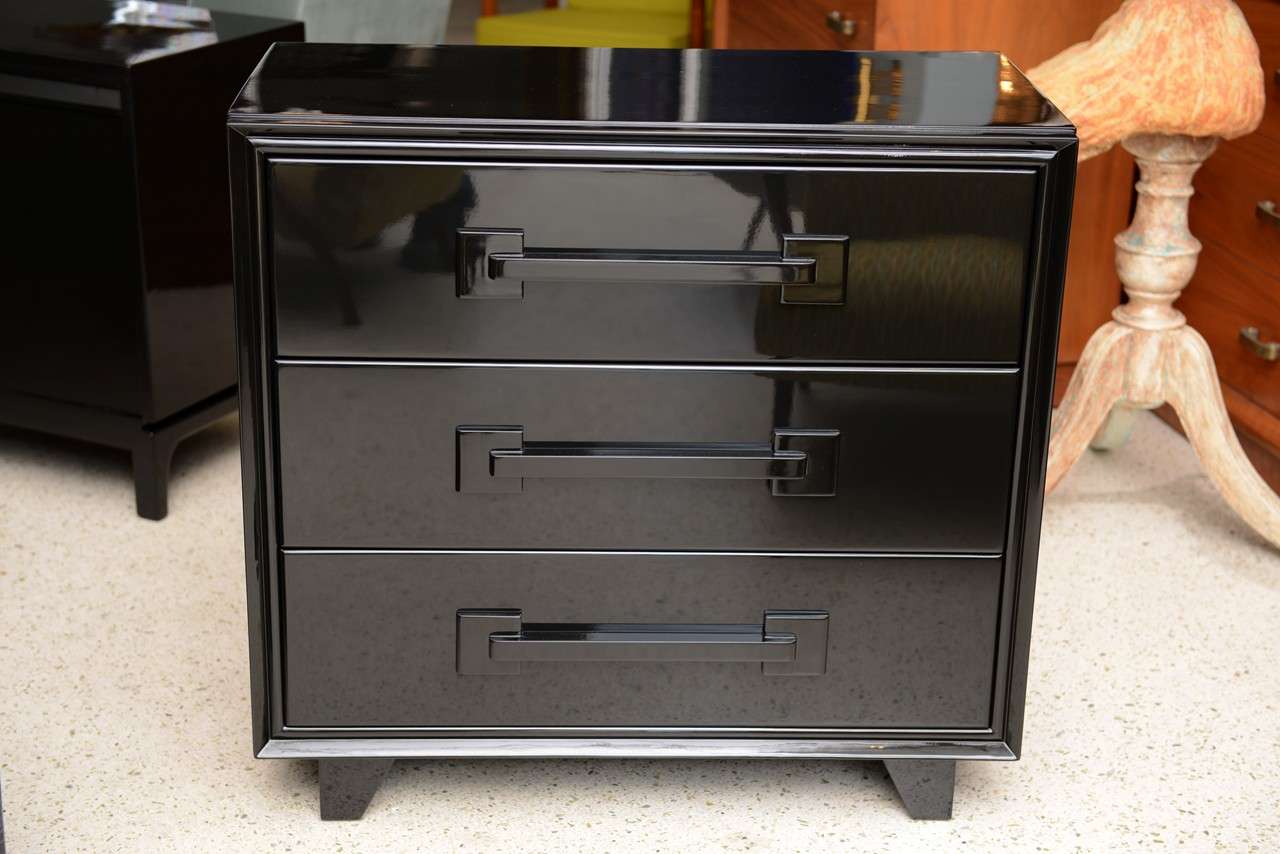 overall in black lacquer with 3 drawers with shaped geometric pulls on canted block feet