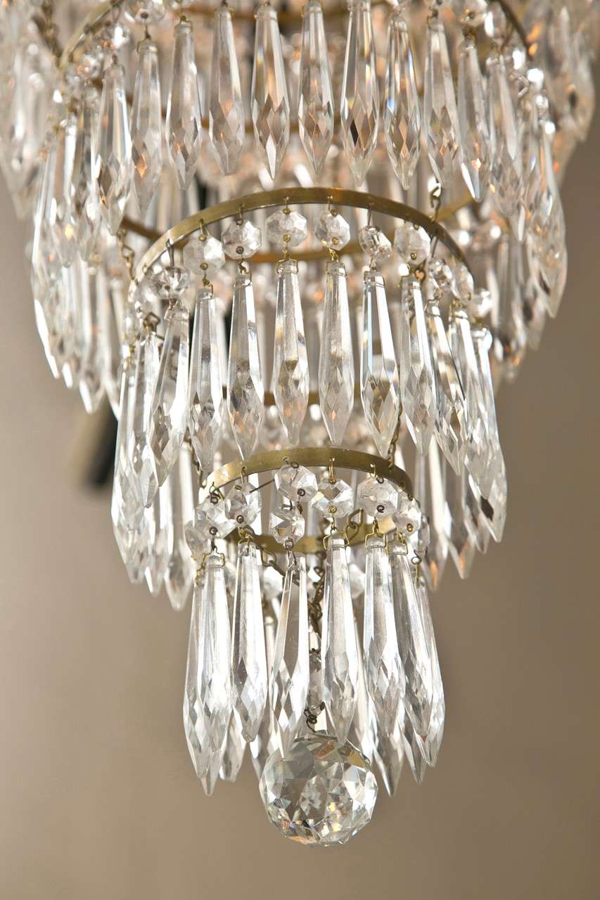 French Empire style crystal chandelier, circa 1920s, 9 bronze arms, 5 have sockets and are lit, decorated with prisms and bobeches, the bottom part of Cascade style. .