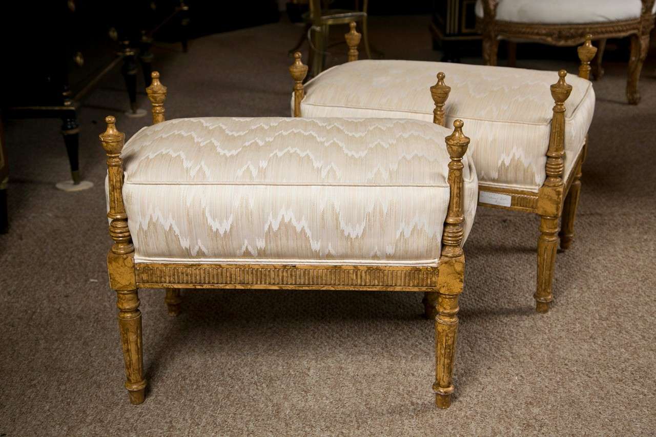 Pair of attractive French Louis XVI style benches, circa 1940s, painted in faux finish, cushioned seat, decorated with finials, raised on short tapering legs.