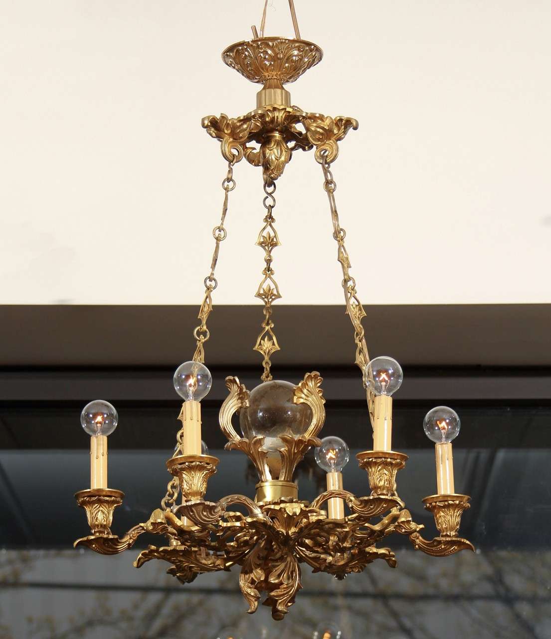 Beautifully detailed six-arm chandelier highlighted with large crystal orb.
