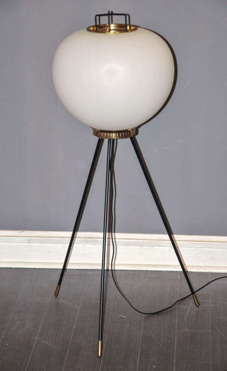1950's Stilnovo floor lamp. Black lacquered metal and brass. White opaline glass shade. One bulb. Wired for European use. Very good condition. Normal wear consistent with age and use.