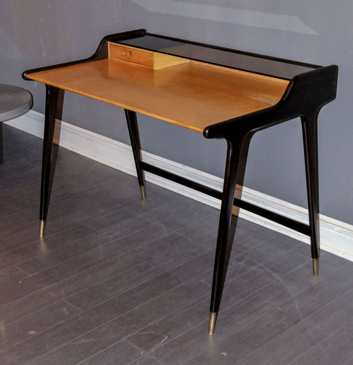 1970's desk by Ico Parisi. Light and ebonized wood. Bronze feet. Smoked glass top. One drawer. Good condition. Normal wear consistent with age and use.
