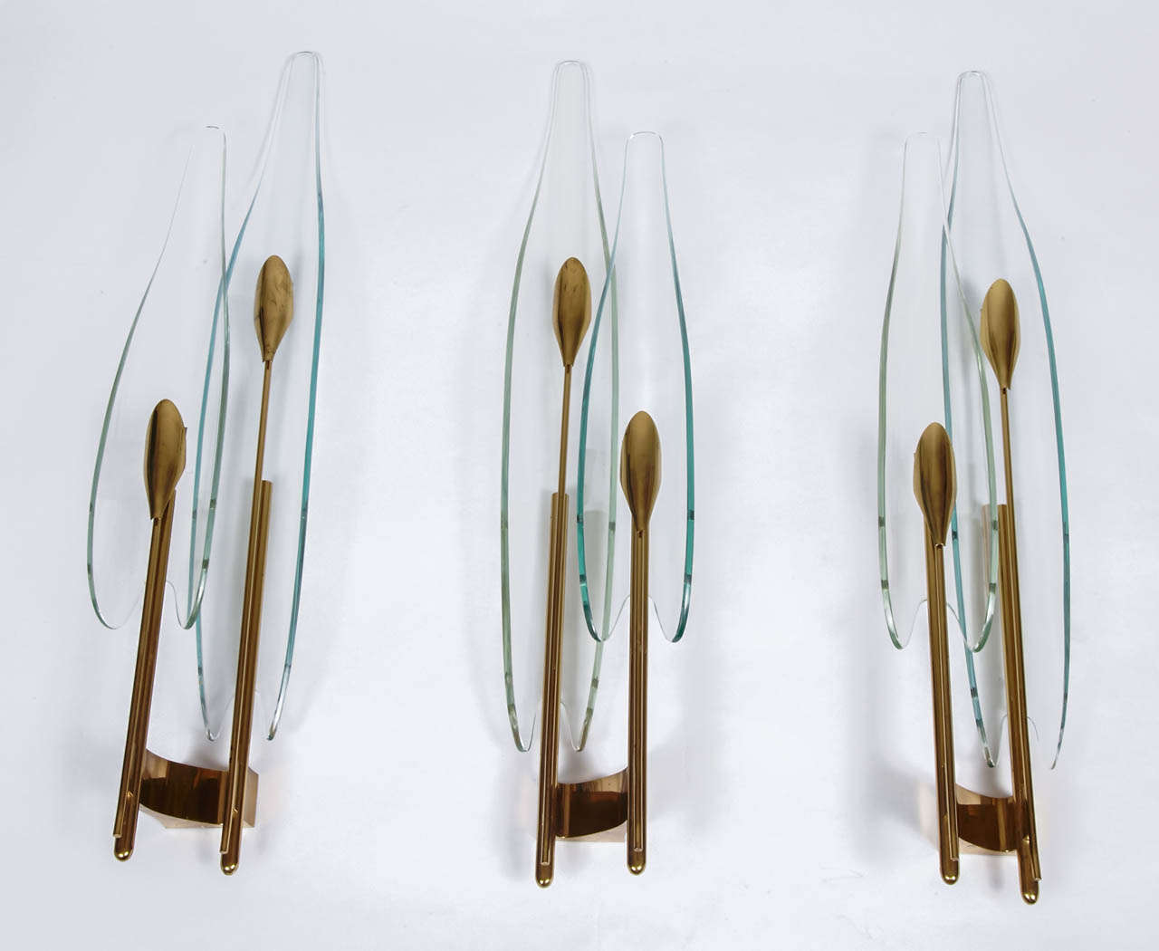 Rare set of three clear curved glass and gilt brass “Dahlia” wall-sconces 
with two arms, by Max Ingrand for Fontana Arte, Italy, circa 1955.

(We can sell a pair at 7000 e).

Ref : Franco Deboni, Fontana Arte : G.Ponti, P.Chiesa, M.Ingrand,