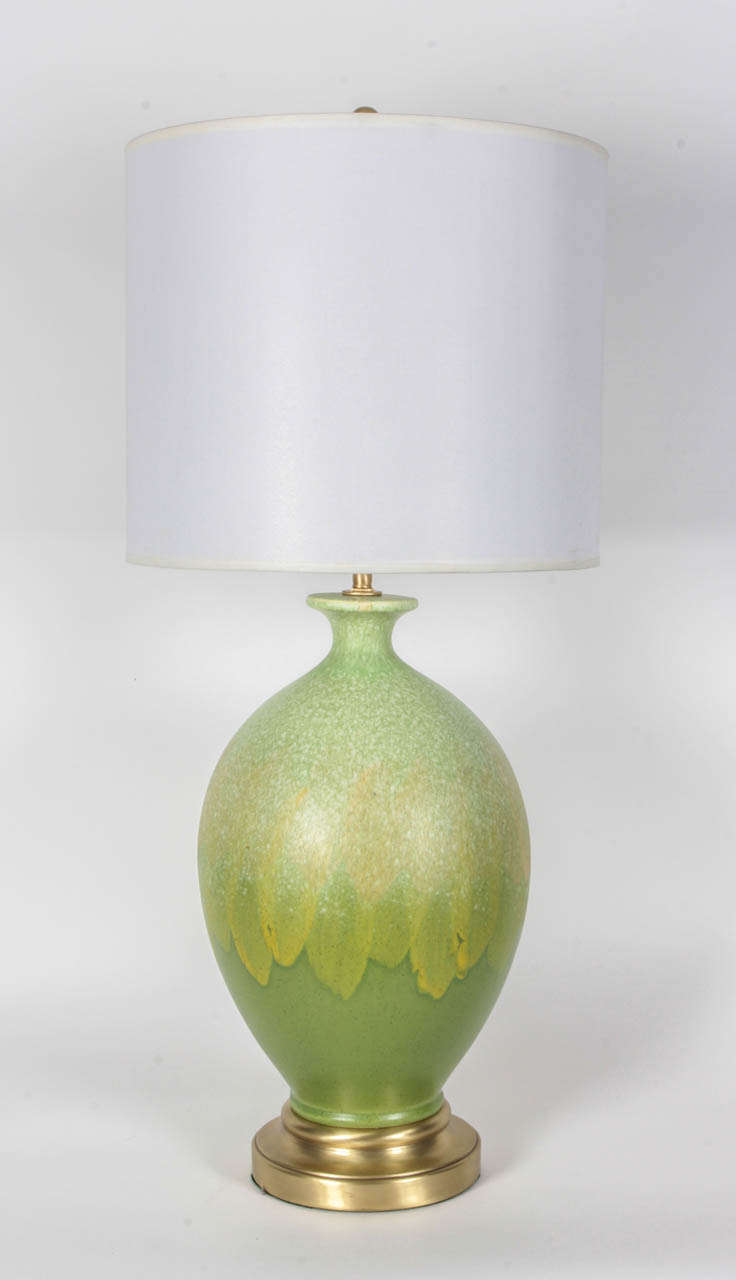 Mid-Century pair of vibriant green matte glazed ceramic lamps with a slightly speckled finish with satin brass bases. Lamps feature double pull chain sockets and new wiring.