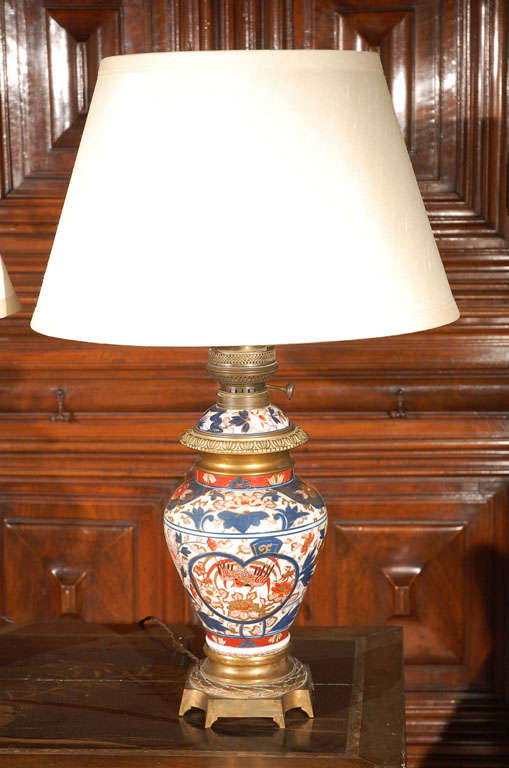 vases Imari en porcelaine peinte à la main, datant du XIXe siècle, avec montures en bronze doré. Anciennes lampes à gaz, mais câblées pour l'exportation. Riche coloration et motif floral luxuriant avec des oiseaux partout.