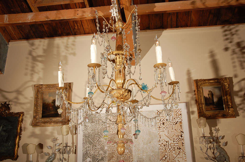 Sparkling, four tier, six-arm, hand-gilded, hand carved wood and crystal chandelier from Genoa, Italy featuring brightly colored flower and acorn drops.