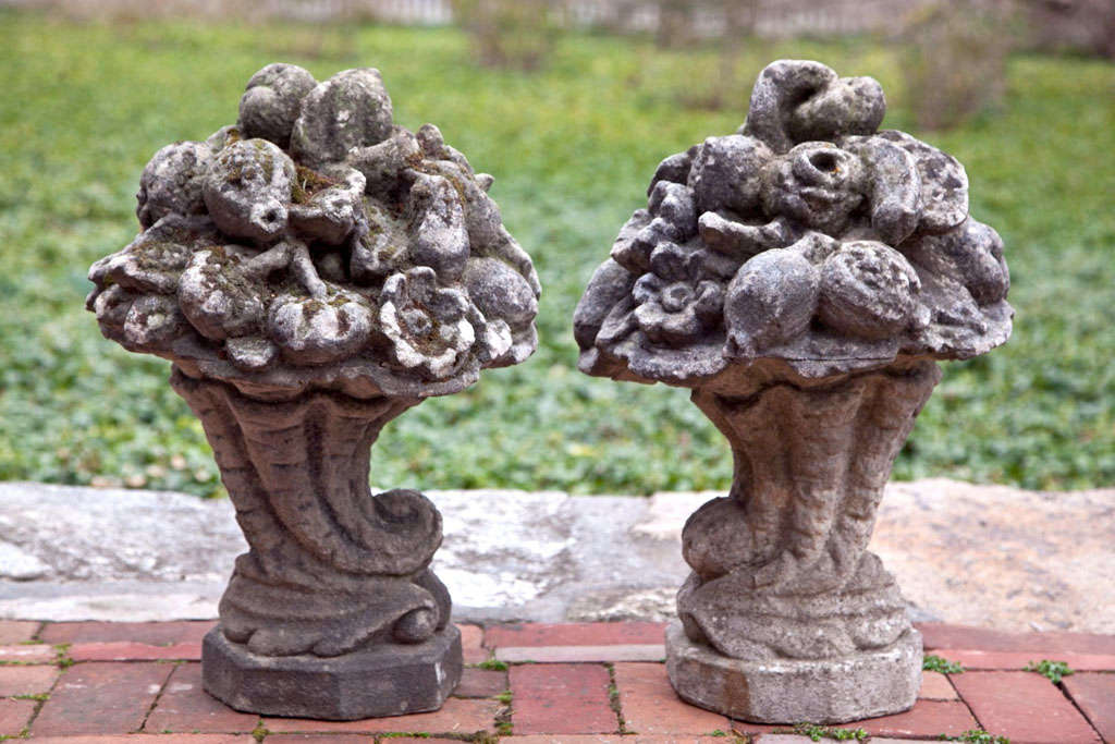 A pair of composition stone cornucopia fruit and flower baskets.