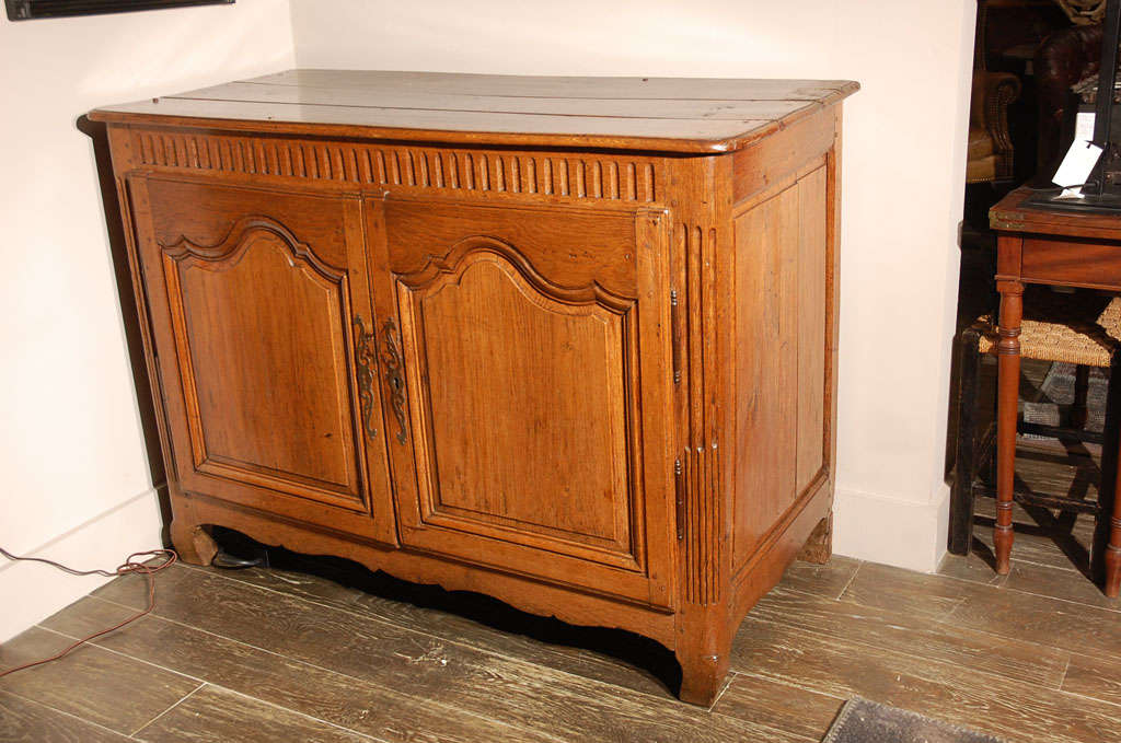 18th century Flemish provincial oak buffet with fluted carving, panel doors, and a carved apron base.