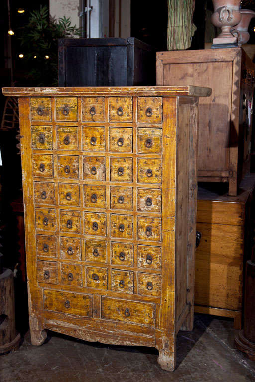 Chinese apothecary cabinet, late 19th century, of 35 smaller herbal drawers and two larger, the front in its original paint decoration. c. 1880-1900