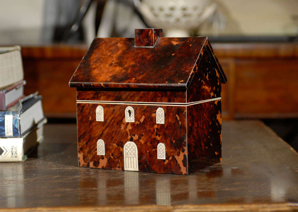 Rare tortoiseshell tea caddy in the shape of a house, inlaid with etched bone.  The top is hollow, interlined with velvet.  Double tea compartments are covered with tortoiseshell lids having bone knobs (one knob is chipped).