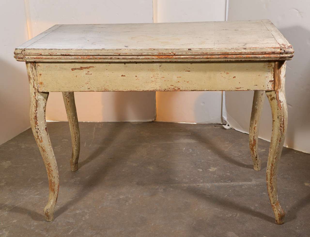 This is an 18th century French table with top that folds open to make a larger table or game table. It's the palest of green/creamy original paint. It has beautiful curvy or cabriolet leg.