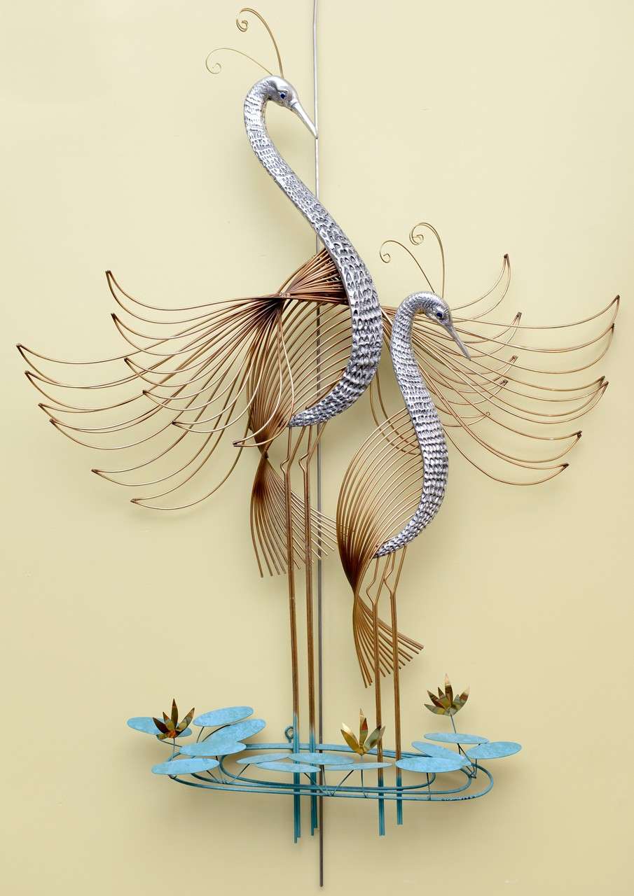Stunning C. Jeré wall sculpture of two birds of paradise or peacocks with wings spread standing amongst water ripples and water lilies. With mixed metals and patinas brass, nickel and verdegris. Wonderfully worked metal sculpture. Signed and