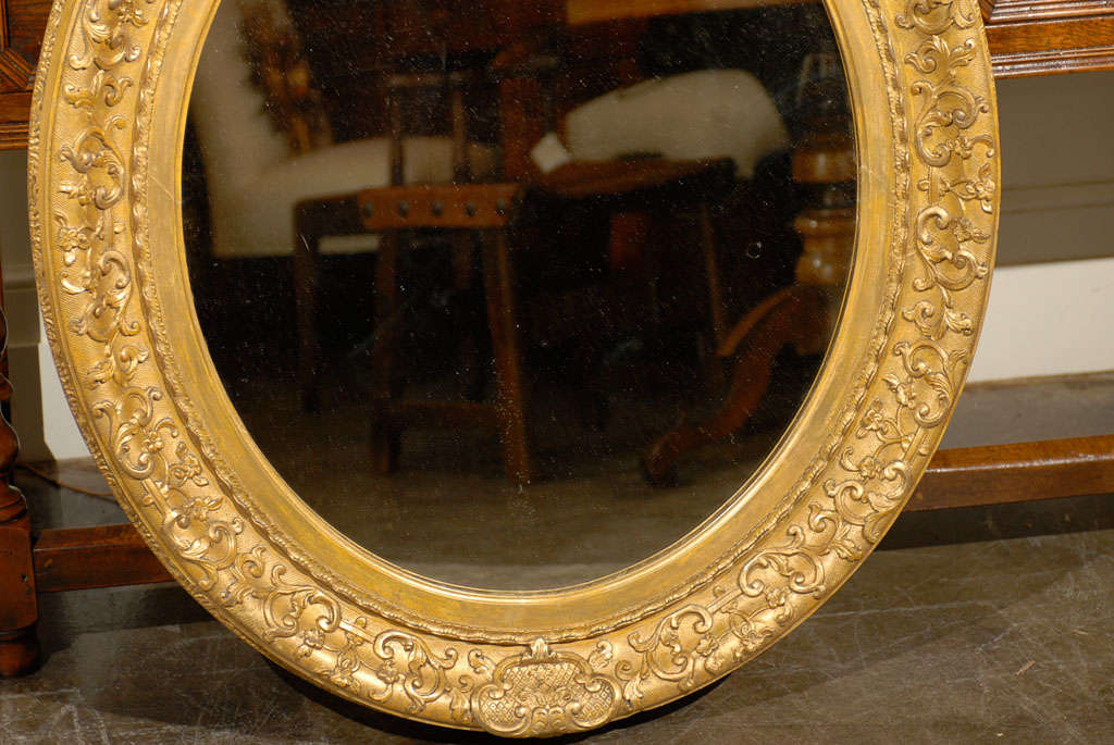 English 1870s Oval Giltwood Carved Mirror with Floral Arabesques and Small Crest In Good Condition For Sale In Atlanta, GA