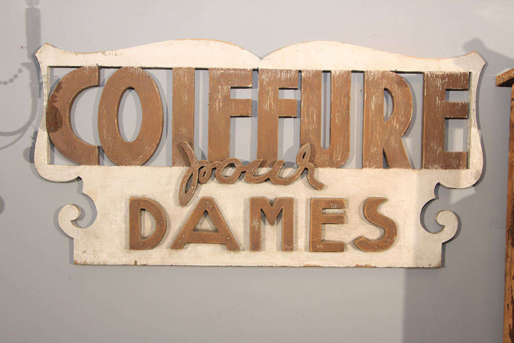 French sign heralding hair styling for ladies.  Three dimensional wood cutouts and differing font make this charming piece perfect for a ladies vanity or dressing area or advertising in a salon.