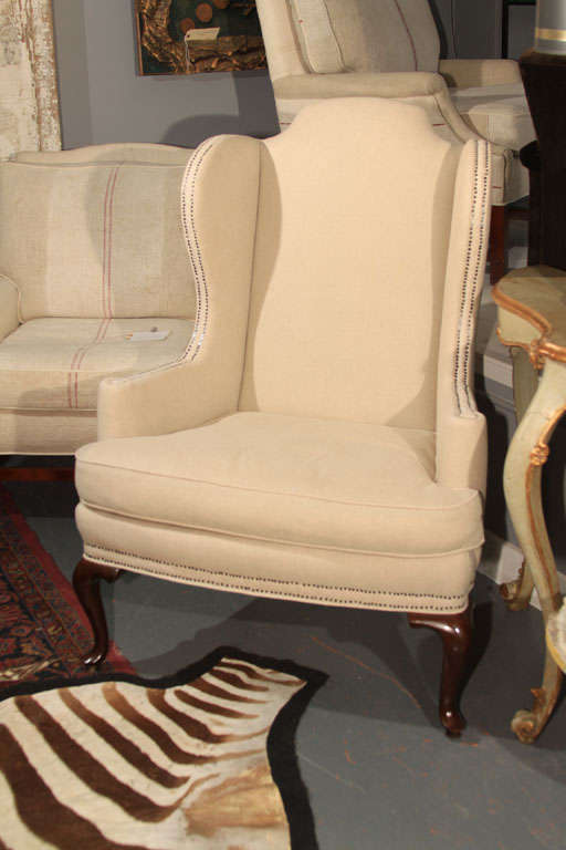 Lovely pair of wingback chairs upholstered in bleached linen with nailhead trim and down cushions.