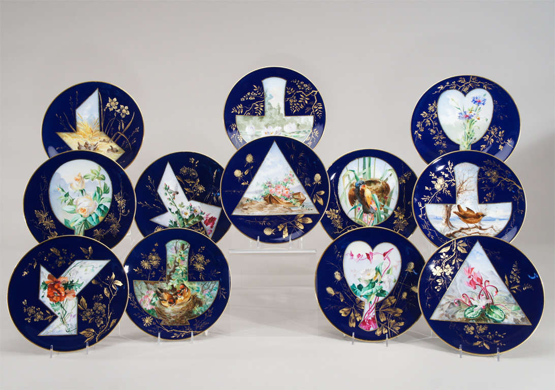 A uniquely decorated set of 12 dessert plates with the most unusual Aesthetic Movement perspective. Each plate is individually hand painted and the specific subject made the focal point by placing it in a fan or geometric shaped reserve. It is as if